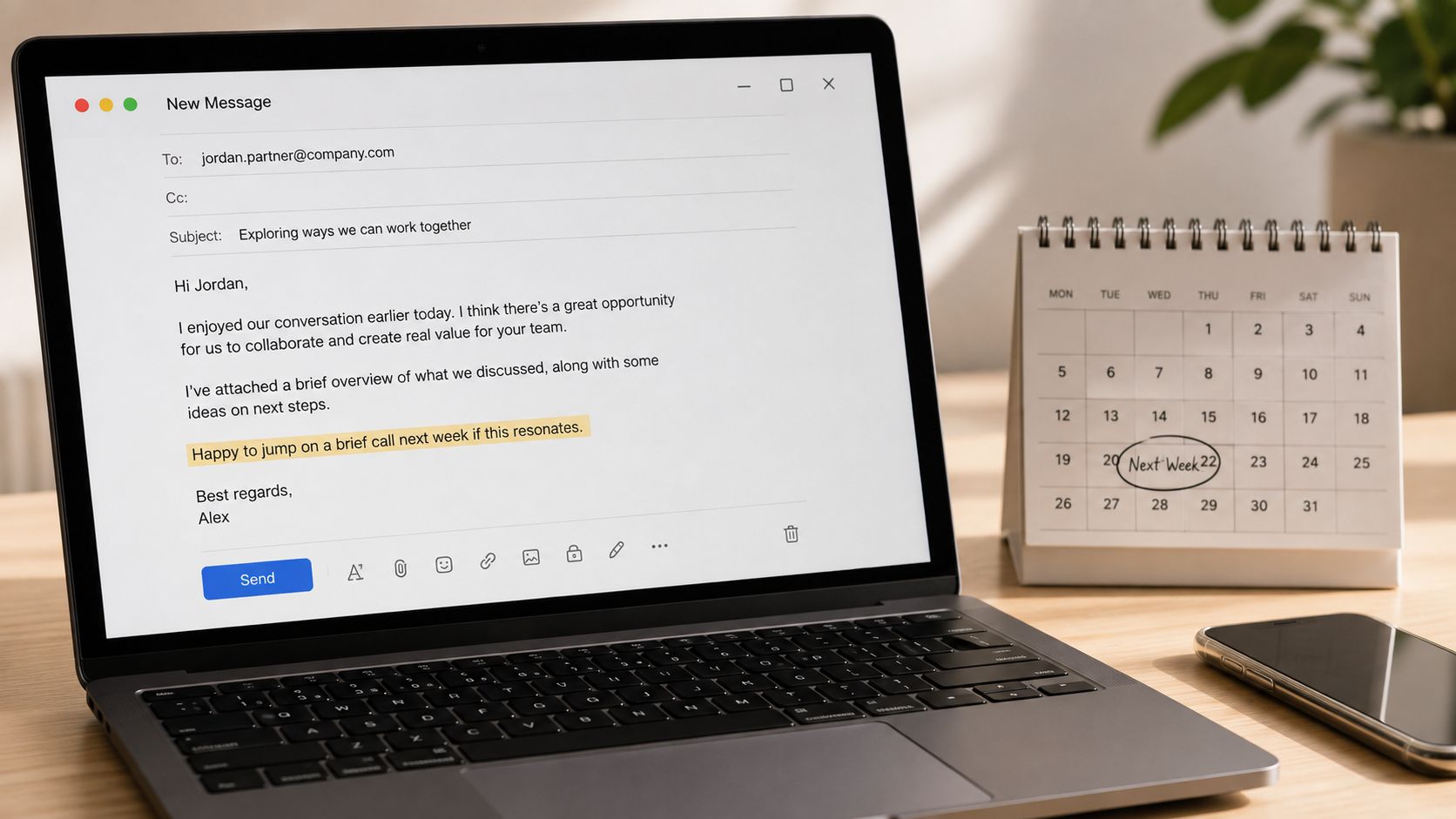 A laptop on a desk showing an email drafted to a partner with a calendar marking next week.